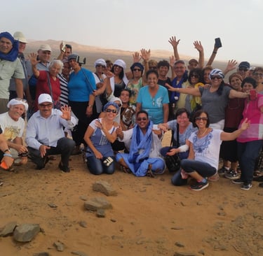 Grupo de turistas brasileiros no Deserto do Saara, passeio de camelo e aventura em Marrocos, turismo