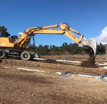 Εκσκαφέας πραγματοποιεί χωματουργικές εργασίες σε κήπο