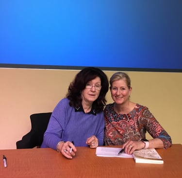 Dr. Sue Johnson and Dr. Bernis Riley sitting at a desk.
