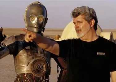 Georges Lucas à coté de C3PO dans le désert sur le tournage de la Guerre des Etoiles