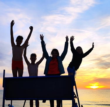 Rodzina w Dąbkach na plaży a w tle zachód słońca.