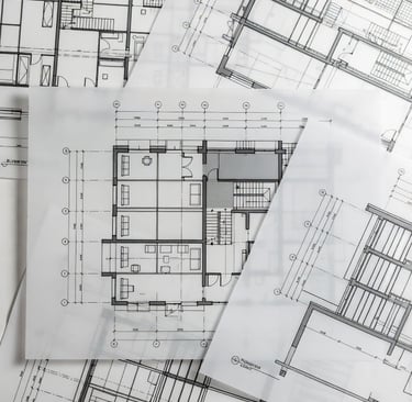 Detailed architectural blueprints and floor plans printed on semi-transparent vellum paper for home construction.