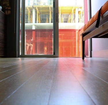 Low-angle view of polished hardwood floors leading to a sliding glass door with city views.