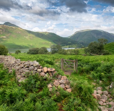 a stone wall with a stone wall and a gate ©Mick Howard