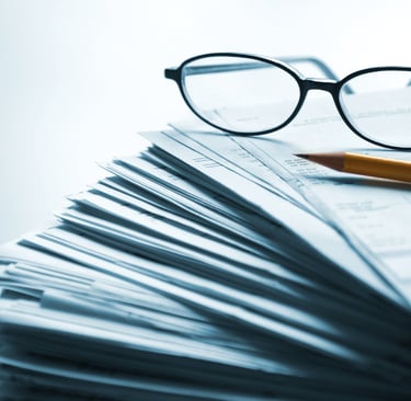 Stack of probate paperwork with reading glasses