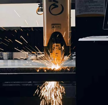 Precision CNC fiber laser cutting machine sparks while processing a metal sheet in an industrial factory.