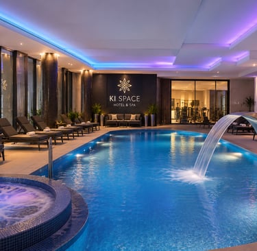 Luxury indoor pool and hot tub at Ki Space Hotel and Spa with mood lighting and lounge chairs.