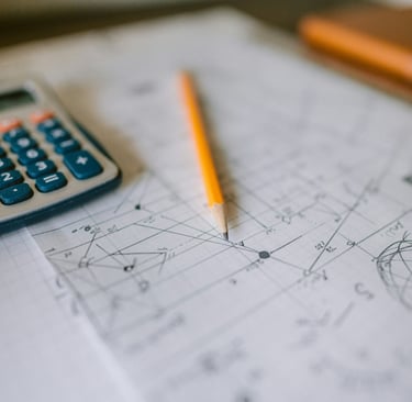 IGCSE mathematics tutoring lesson notes written on a paper script along side a calculator