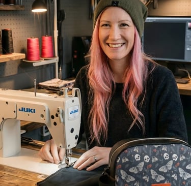 Kooksey Founder Jenni sat at wooden desk in front of a monitor designing fabric