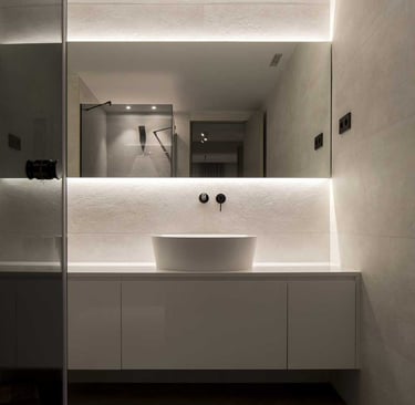 Detalle de espejo con perfiles LED superiores e inferiores para luz uniforme.