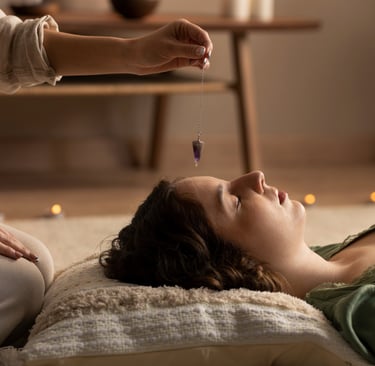 Terapeuta holística trabaja con un péndulo en sesión de reiki para armonizar la energia