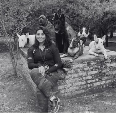Entrenadora canina sonriente con un grupo de perros de distintas razas en San Luis Potosí