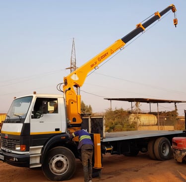 A telescopic boom truck mounted crane lifting a truck.