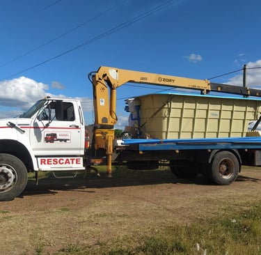 A truck with a large container on it, equipped with a telescopic boom truck mounted crane.