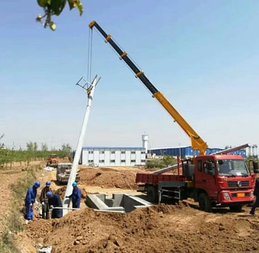 A telescopic boom truck mounted crane lifting a large object over a field.