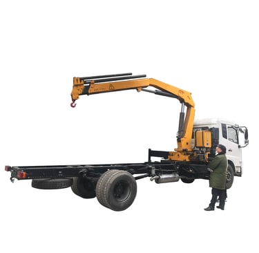 A man stands beside a robust crane with a 6.3 Ton Knuckle Boom. The crane's hexagon and pentagon boom design ensures stabilit