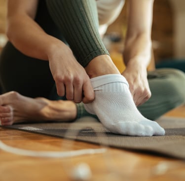 person putting on pilates grip socks 