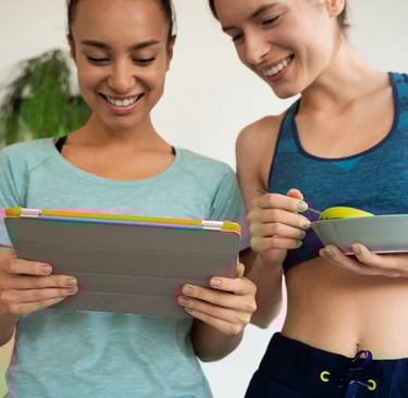 Two fitness women looking at ipad