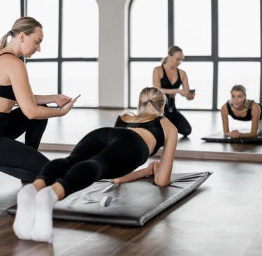 Trainer timing woman doing forearm plank