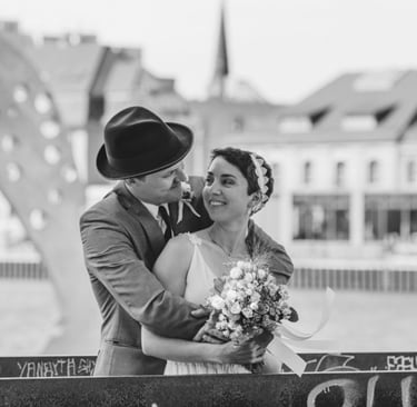 Der Bräutigam umarmt die Braut von hinten.