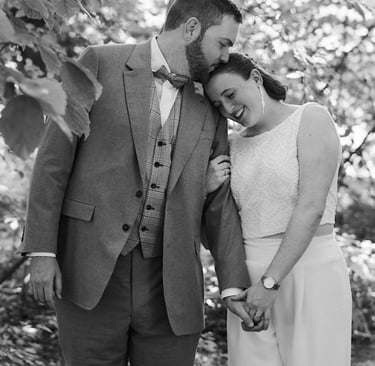 Bride and groom walking in a park.