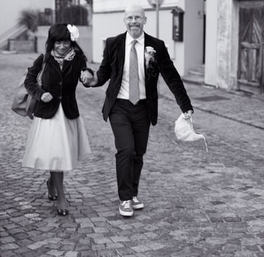 Braut und Bräutigam spazieren auf einer gepflasterten Straße.