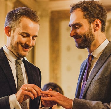 Homosexuelle Bräutigame tauschen Ringe aus.