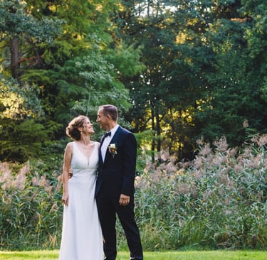 Reife Jungvermählte stehen in einem Park.