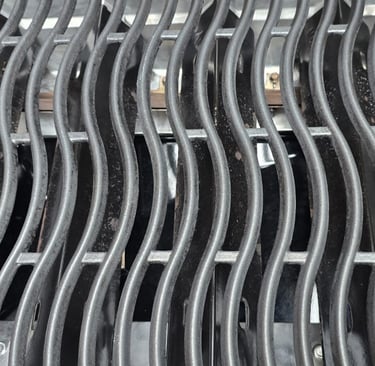 Close-up of professionally cleaned BBQ grill grates showing spotless finish