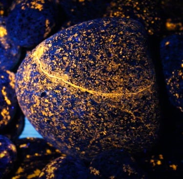 Orange glowing yooperlite rocks under 365nm uv light.