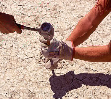 People hammering anchor to the playa dirt