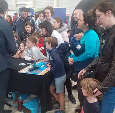 alain surirna is standing in front of a table with child explaining sharks