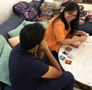 A happy Mansi setting up and demonstrating the game Codenames.