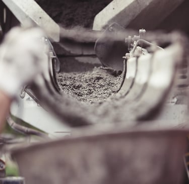 a person is putting cement into a bucket