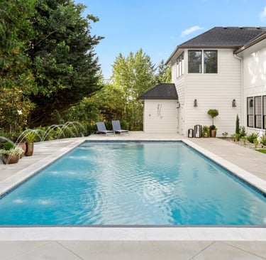 a pool with a waterfall in the concrete deck