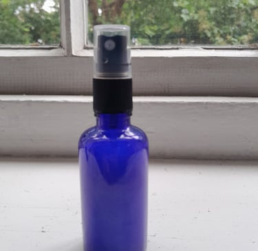 An image of a homemade therapy product called Vibrational Room Spray in a blue spray bottle..