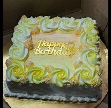 "Freshly baked pineapple birthday cake decorated with whipped cream, pineapple slices, and cherries,