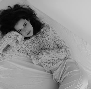 a woman laying on a bed with her hand on her head