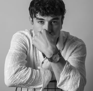 a man sitting in a chair with his hands on his chin