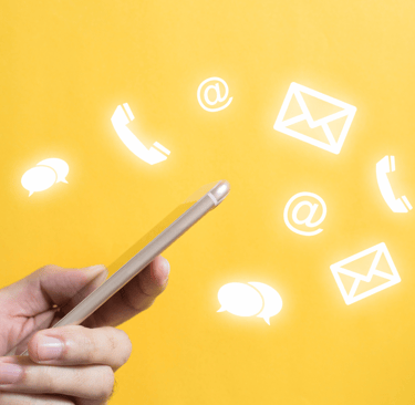 a person holding a cell phone with contact icons floating in the background.