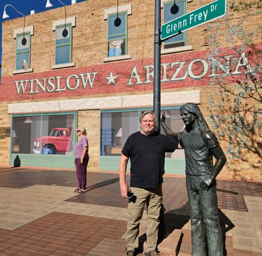 A tourist stands by the Glenn Frey statue at Standin' on the Corner Park in Winslow, Arizona.