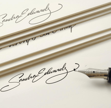 Elegant handwritten signature on ivory stationery paper with a luxury fountain pen.