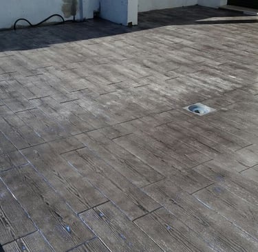 Superficie de hormigón impreso con acabado de imitación madera, perfecta para terrazas y exteriores modernos.
