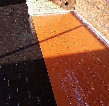 Superficie de hormigón impreso con acabado en resina de dos colores, ideal para crear contraste en áreas exteriores.