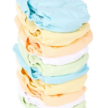 Newborn diapering essentials including diapers, wipes, rash cream, and changing mat.
