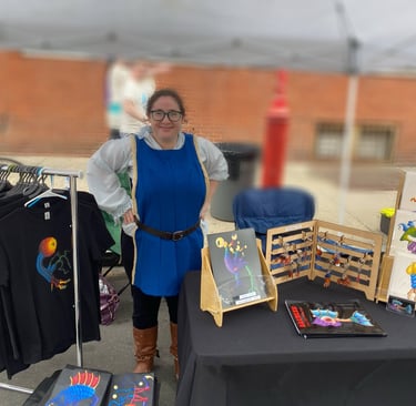 Rose wearing garb at their booth at Queen and Rook Fantasy Renn Faire