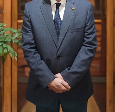 Major General Ayman Syedelahl stands wearing an elegant grey suit, with luxurious office decor