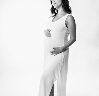 Photo de maternité, dans une robe blanche pour marquer ses courbes de grossesse