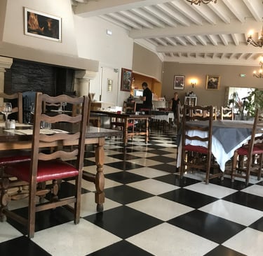 Rustic restaurant interior with black and white checkered floors, In Quillan.