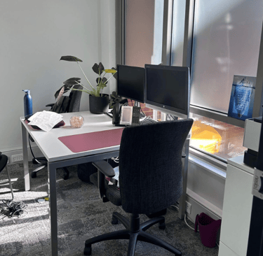a desk with a computer monitor and a desk with a chair